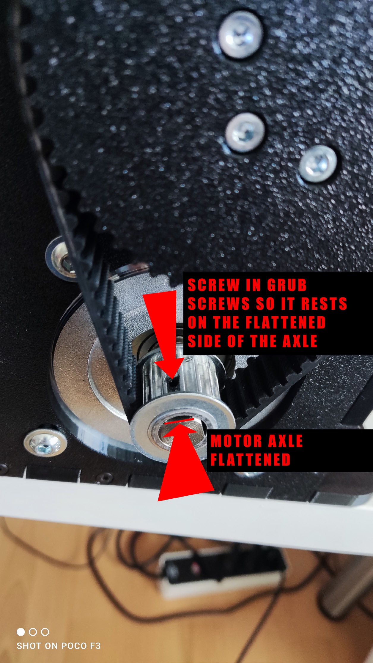 Close-up showing the pulley grub screw aligned with the flattened motor shaft